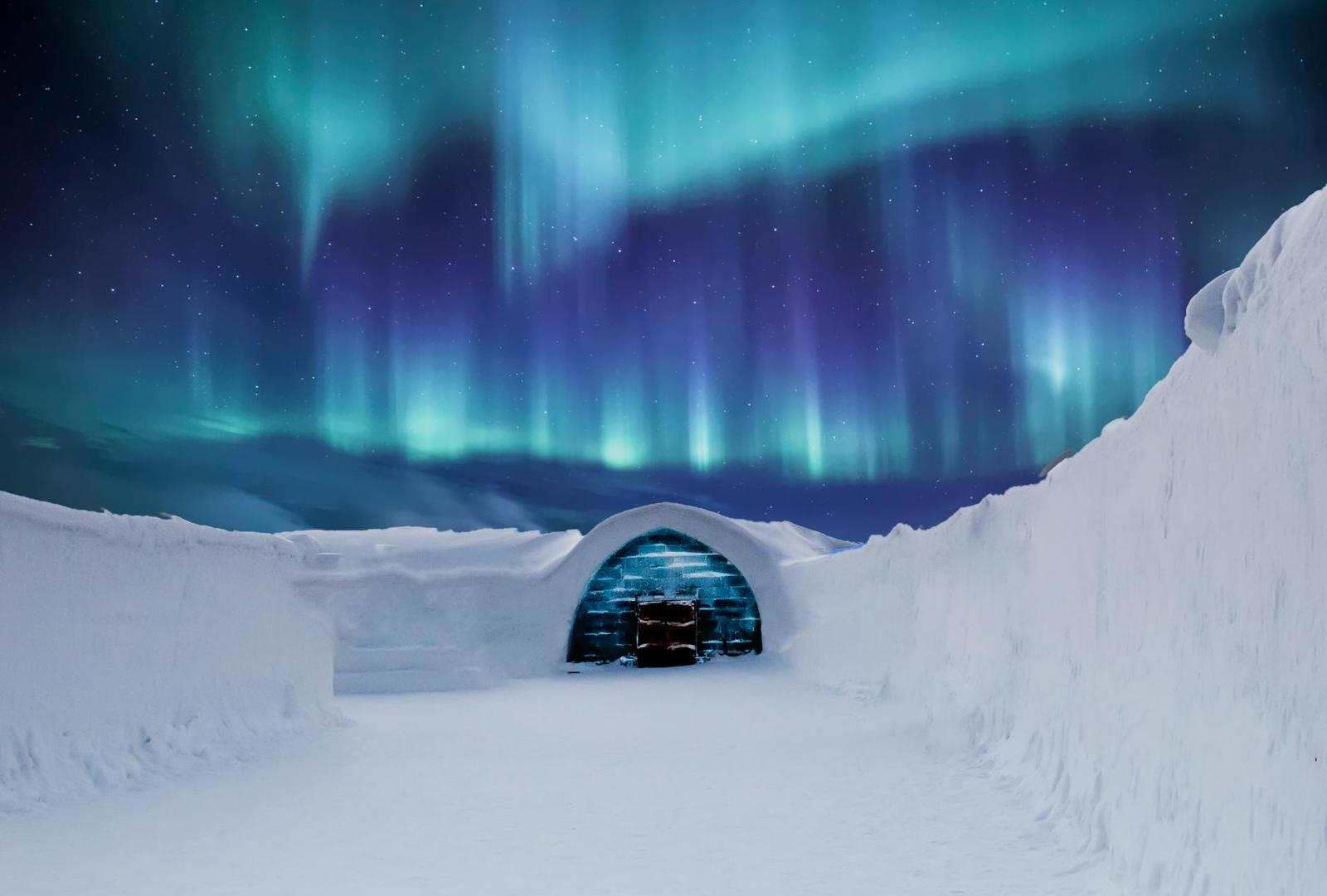 Northern lights glowing above an igloo-shaped ice structure at night