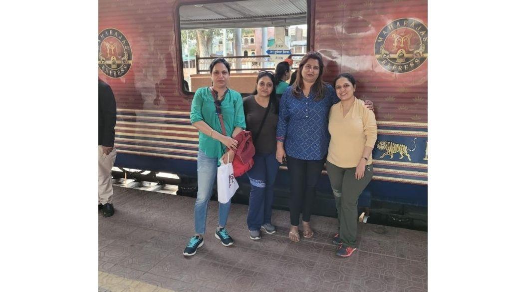 Group of women posing in front of a luxury train.