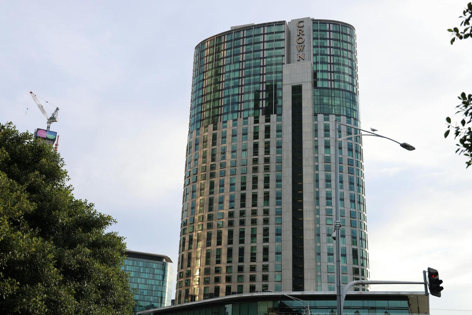 A curved glass hotel tower photographed from a city street below