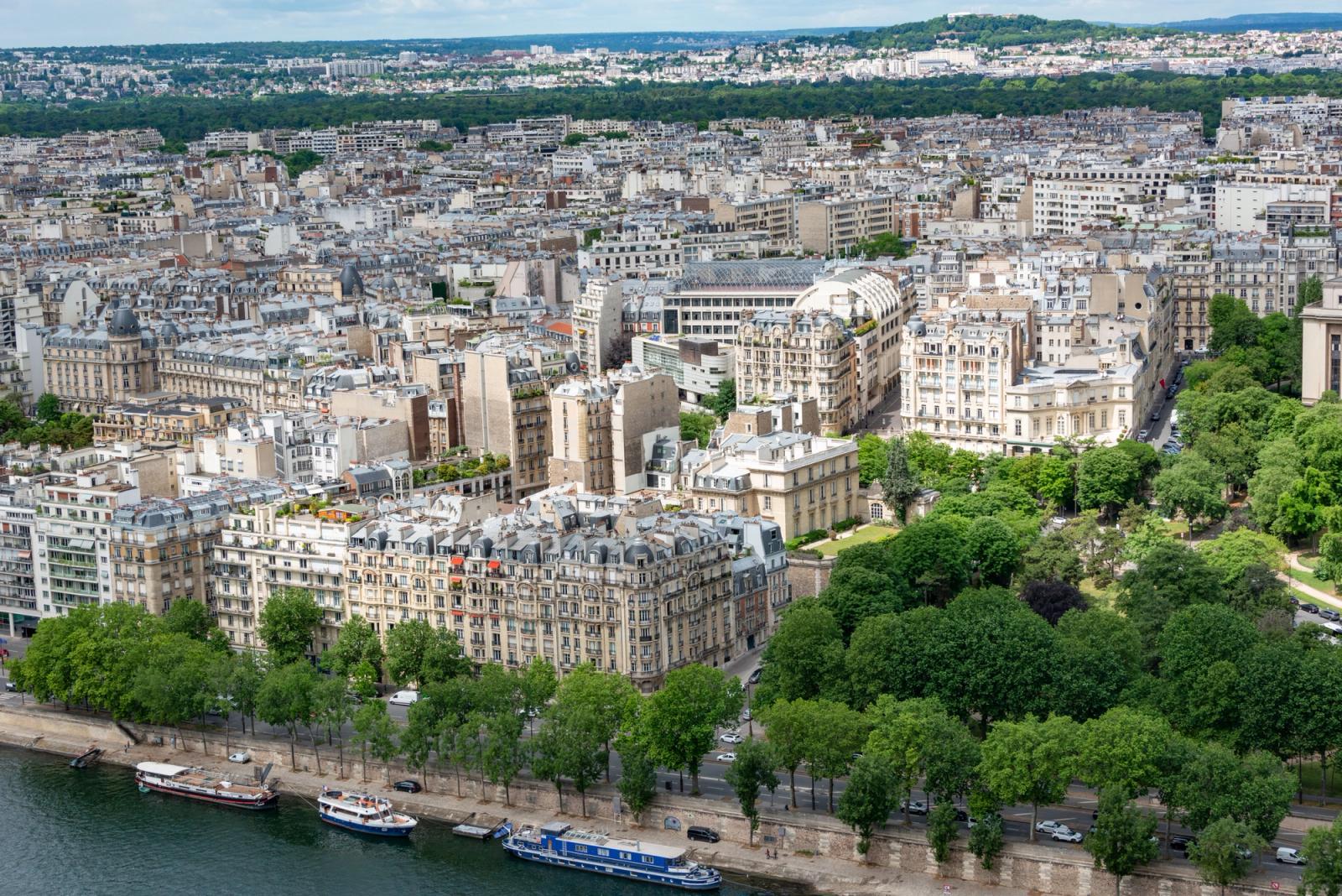 A stunning aerial view showcasing the cityscape of Paris along the Seine River, highlighting classic architecture