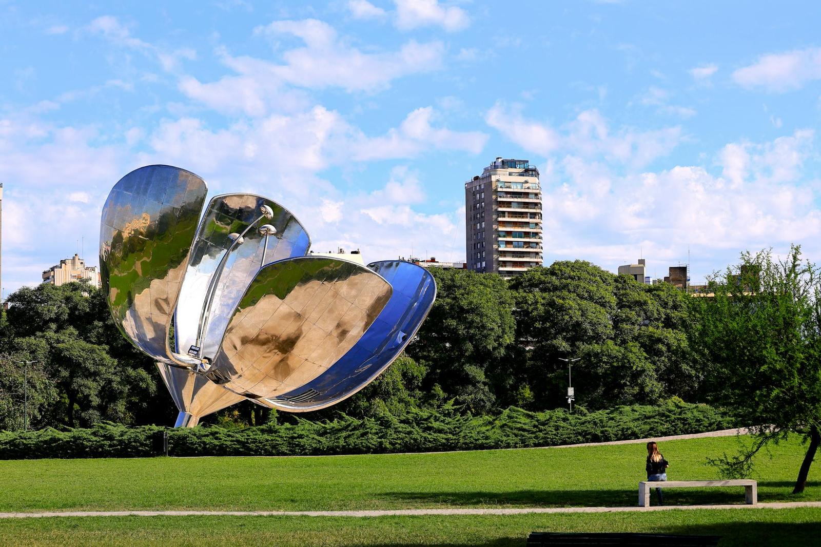 Floralis Generica sculpture in a Buenos Aires park with buildings in the background