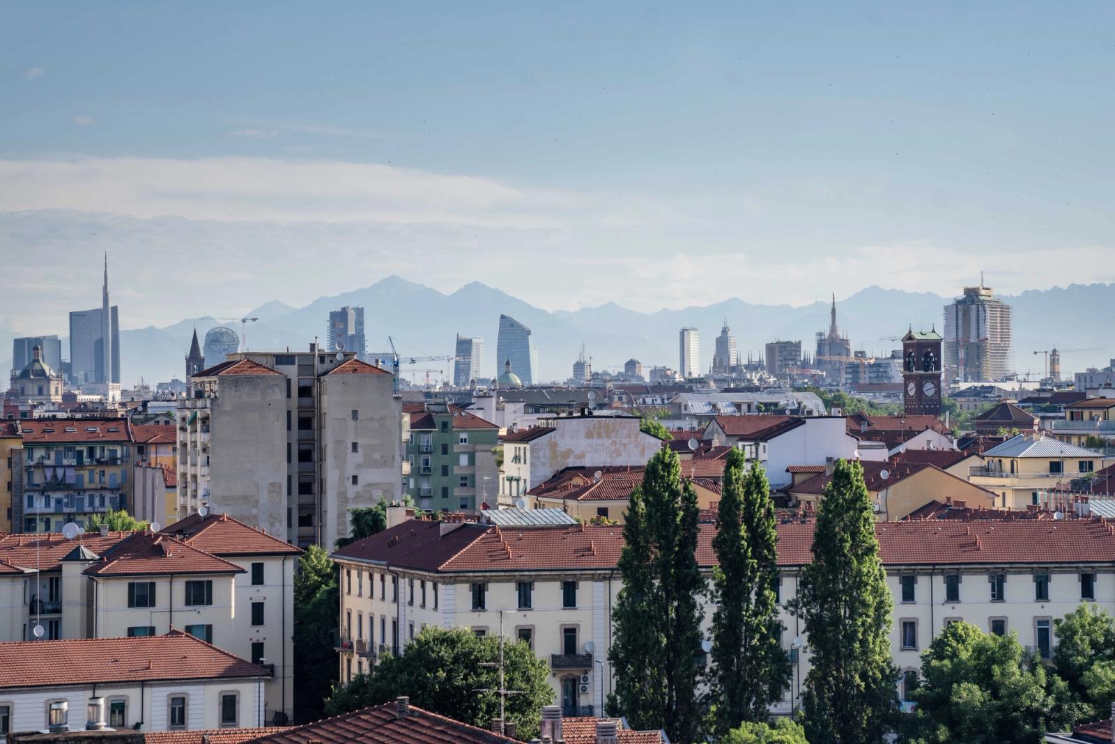 Stunning aerial view of Milan's skyline with famous architecture and mountains in the background