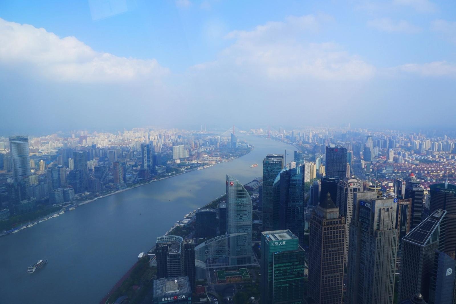 A breathtaking aerial cityscape of Shanghai, China, featuring skyscrapers along the Huangpu River