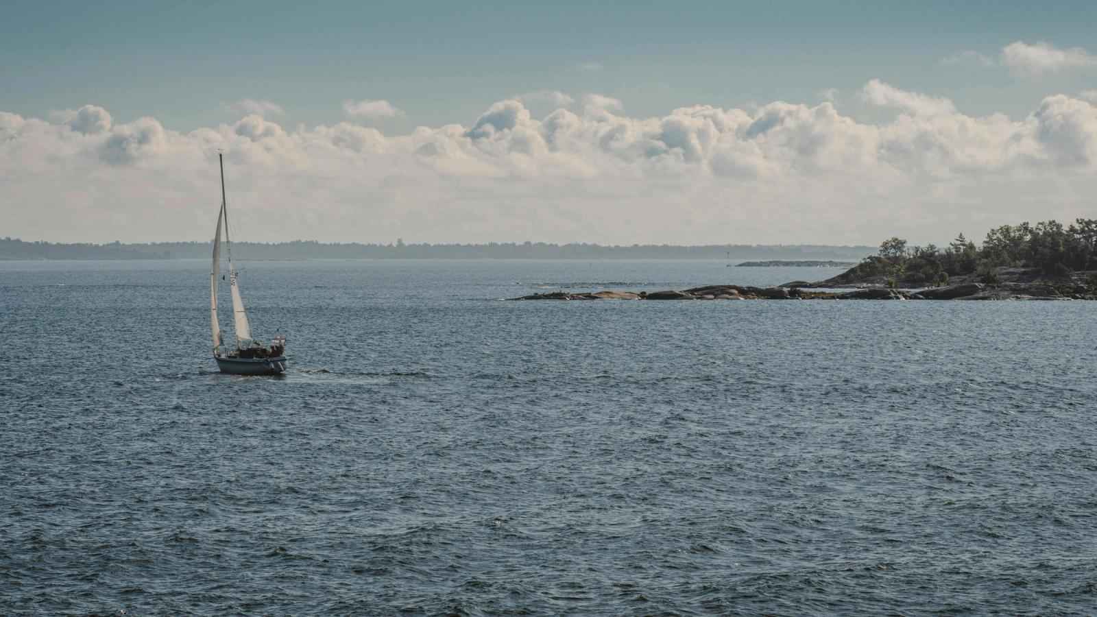 Scenic view of a sailboat cruising through the serene waters of Finland's archipelago region
