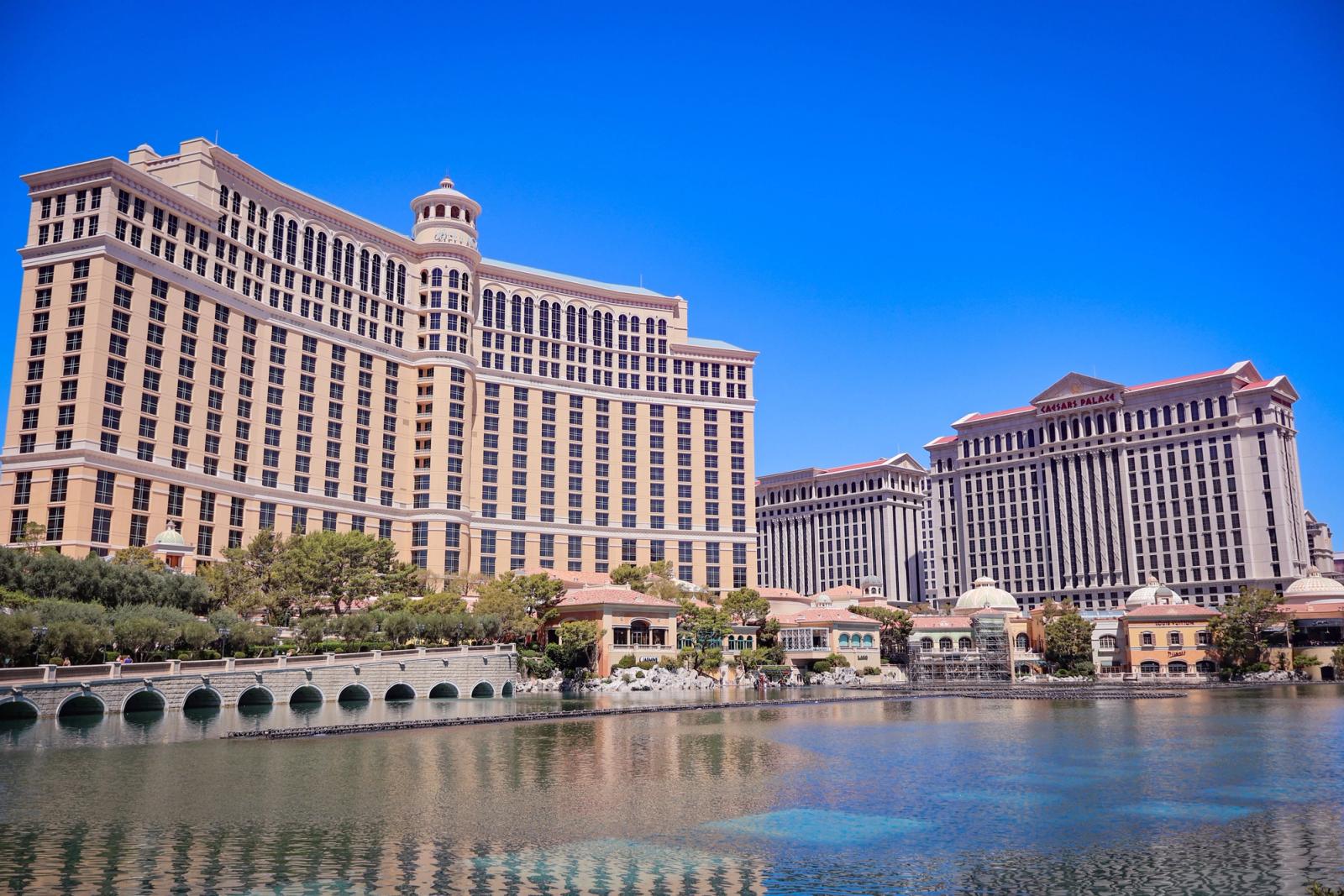 Stunning daylight view of the Bellagio and Caesars Palace in Las Vegas with a clear blue sky and reflective waters
