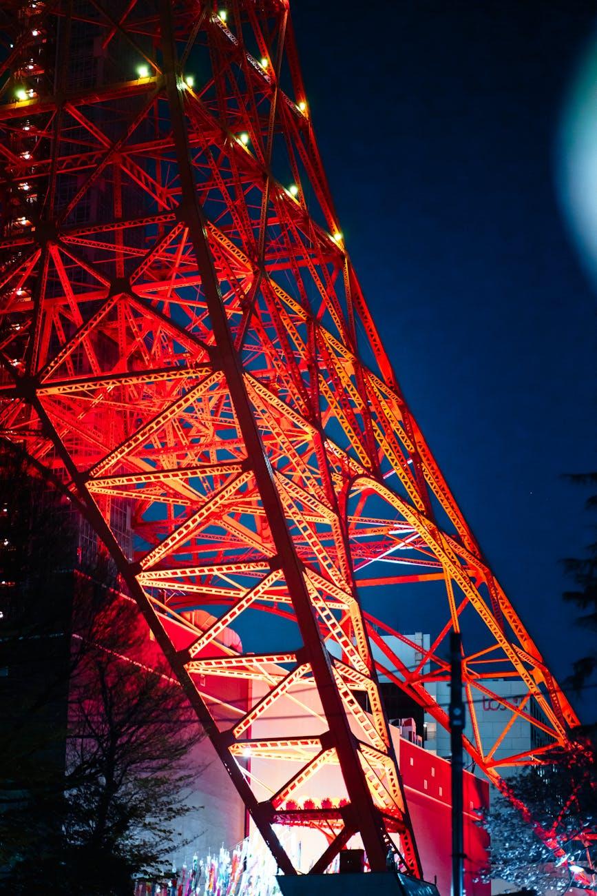 A vibrant night view of the illuminated red steel structure of Tokyo Tower, Japan
