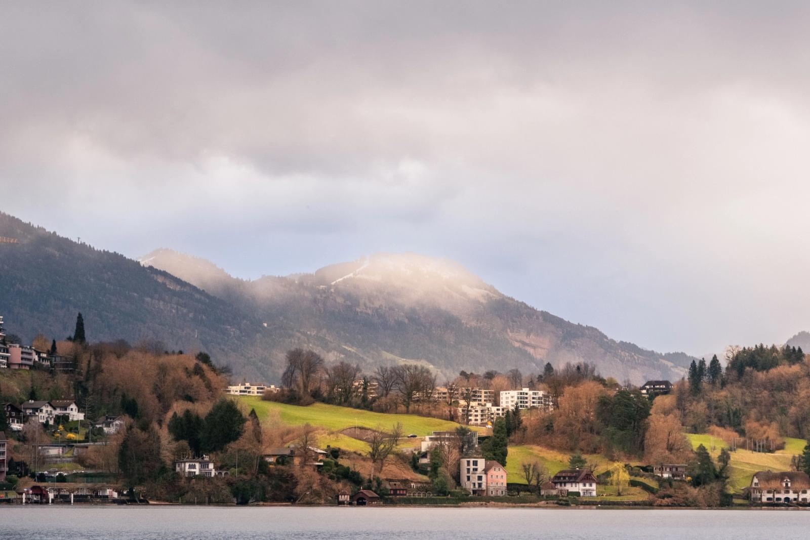 Beautiful landscape of Lucerne with hills, residential areas, and Lake Lucerne under cloudy skies
