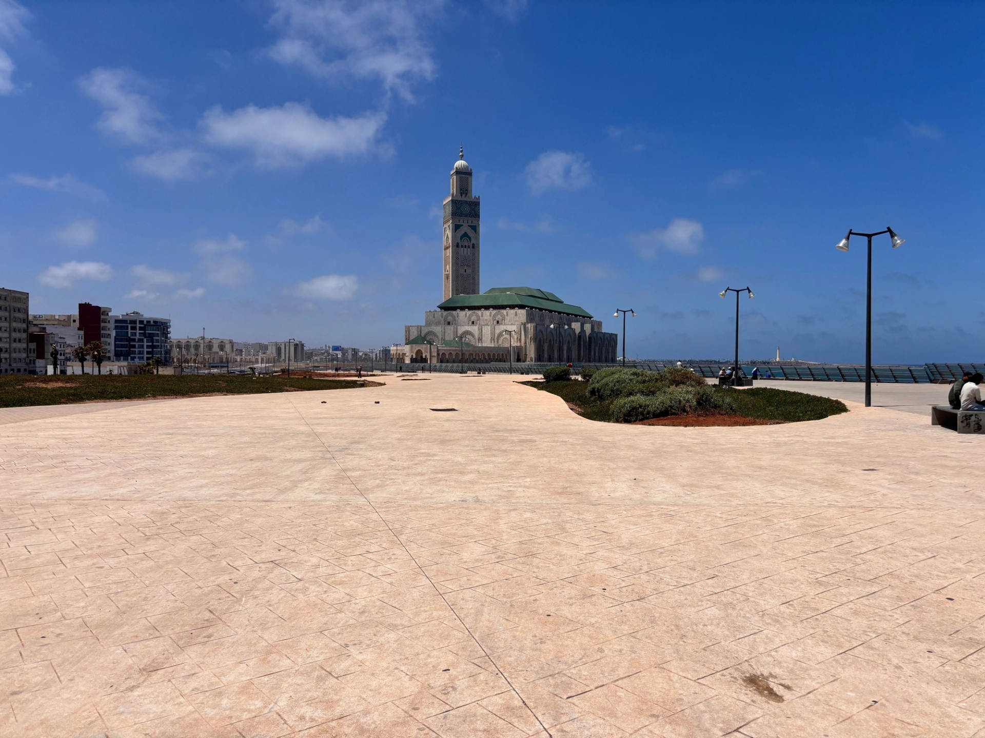 A view of Hassan II Mosque in Casablanca with a clear blue sky and open plaza