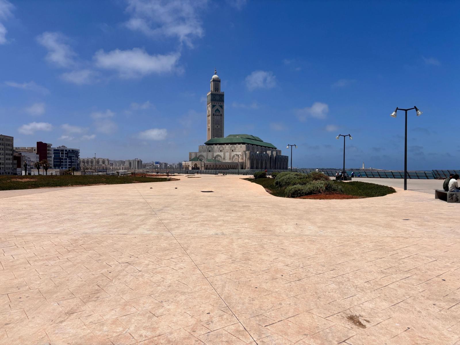 A view of Hassan II Mosque in Casablanca with a clear blue sky and open plaza