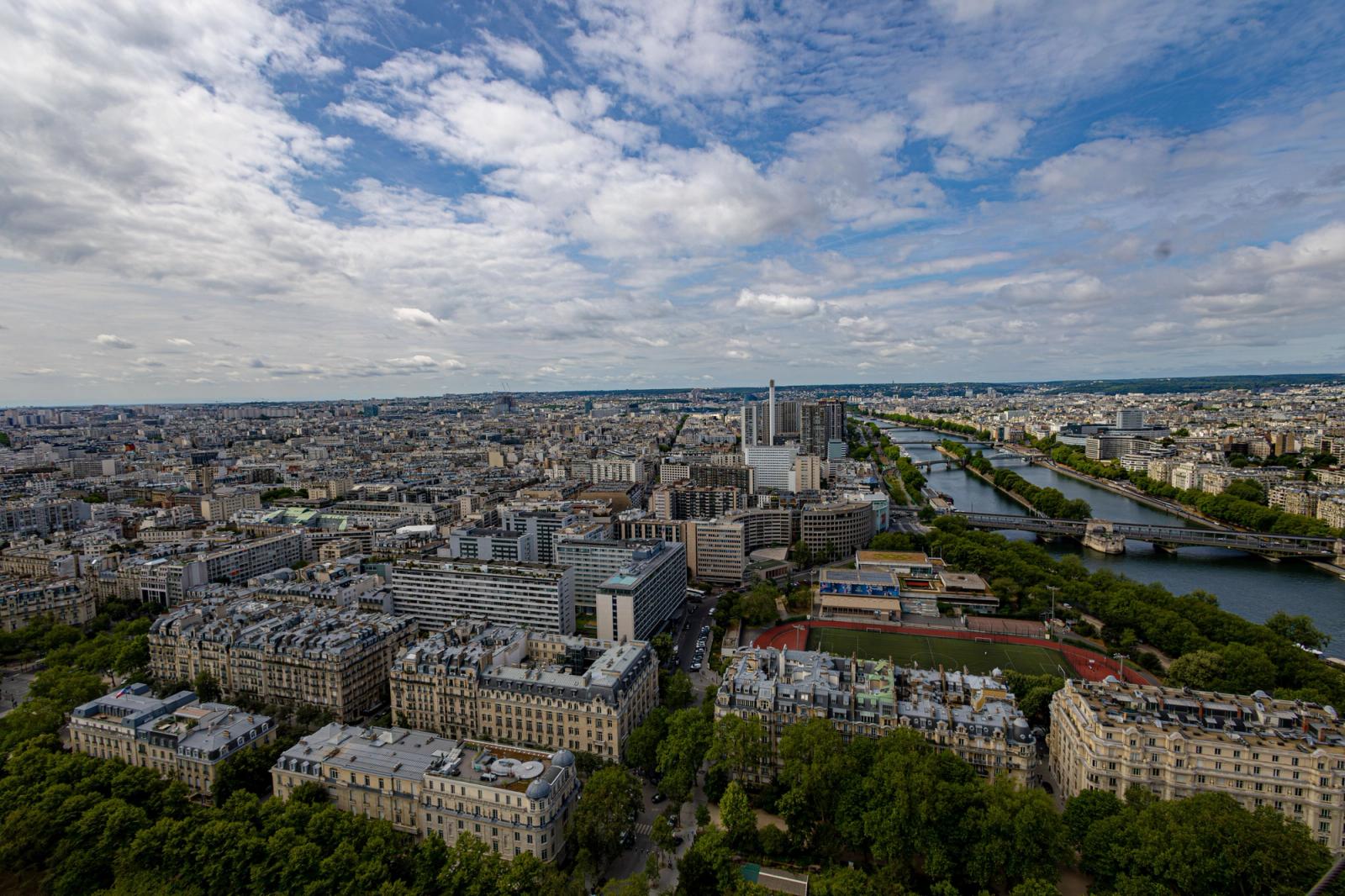 Stunning aerial view of Paris, showcasing the cityscape and River Seine under a partly cloudy sky