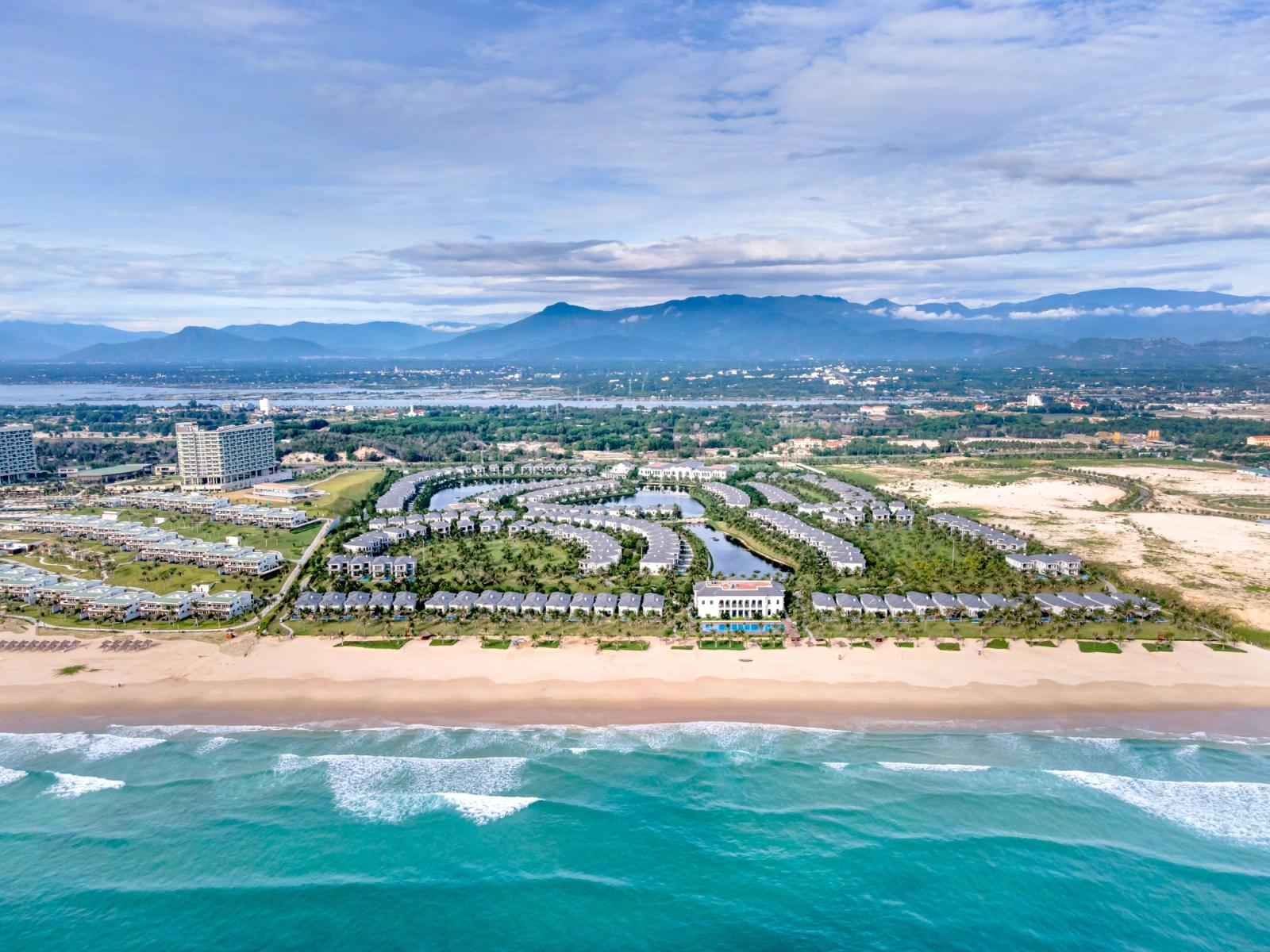 Stunning aerial view of a luxurious resort along the Vietnam coastline with turquoise sea and sandy beach