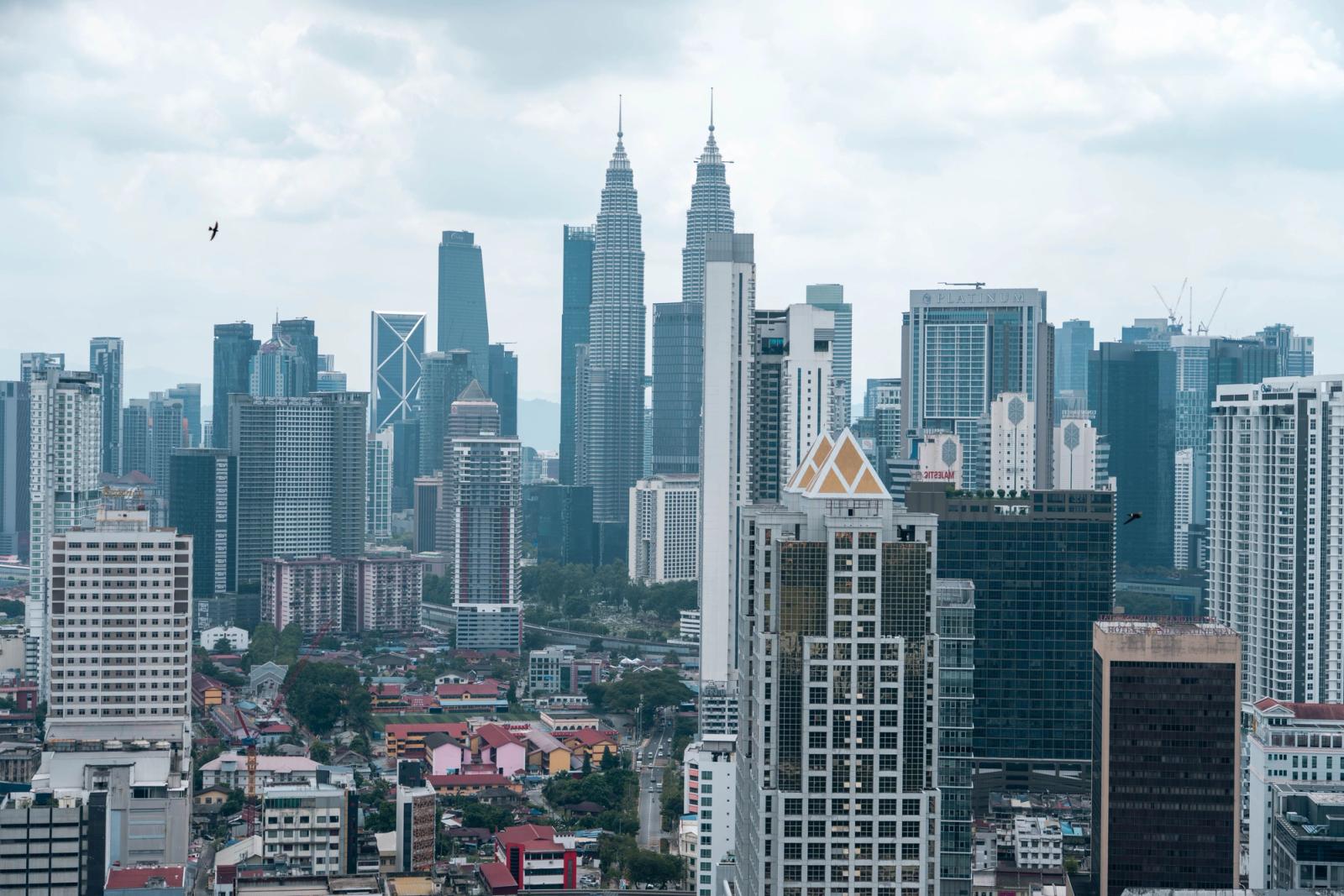 Stunning aerial view of Kuala Lumpur cityscape showcasing the iconic Petronas Towers and high-rise buildings