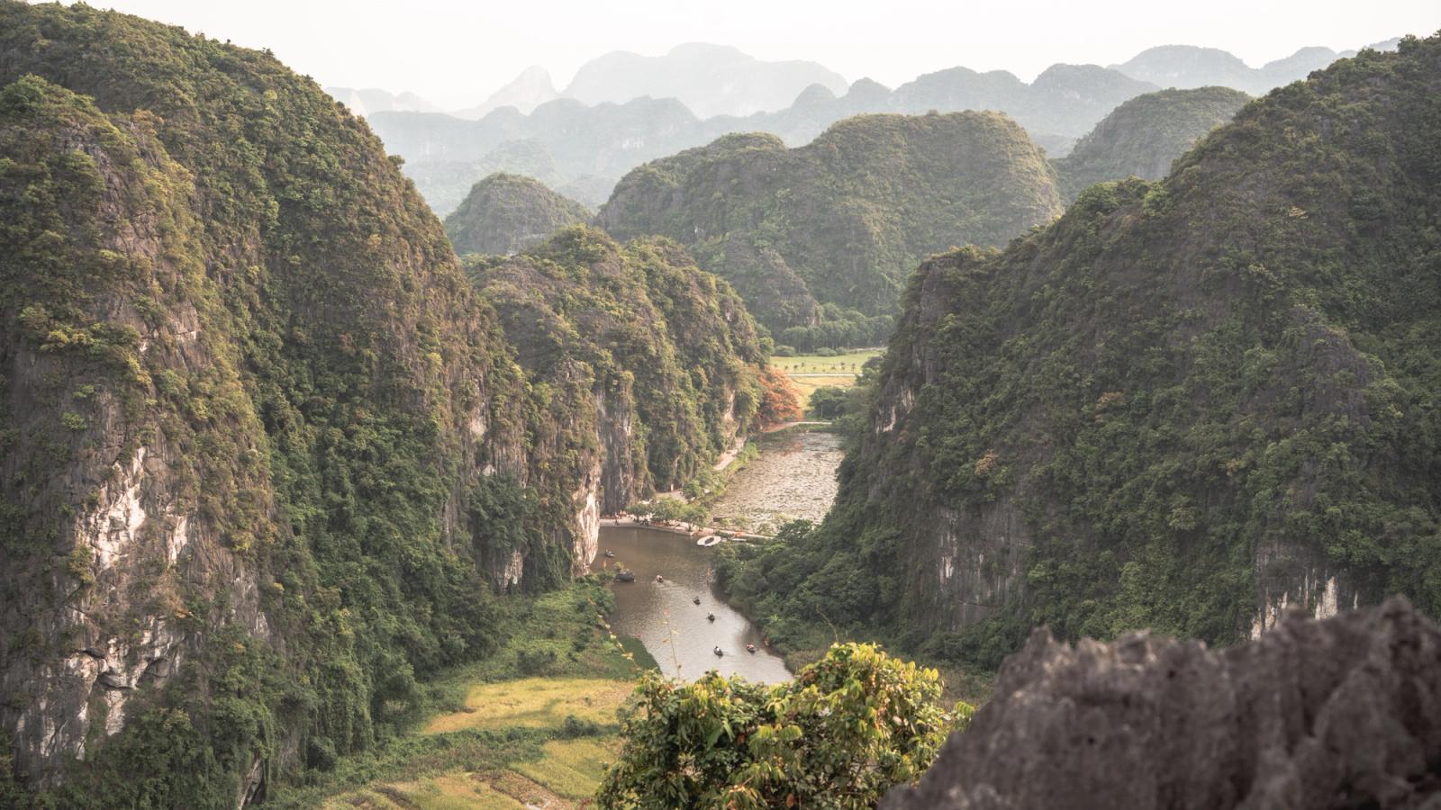 Explore the lush limestone mountains and calm river in Nam Hoa Lu, Ninh Binh, Vietnam