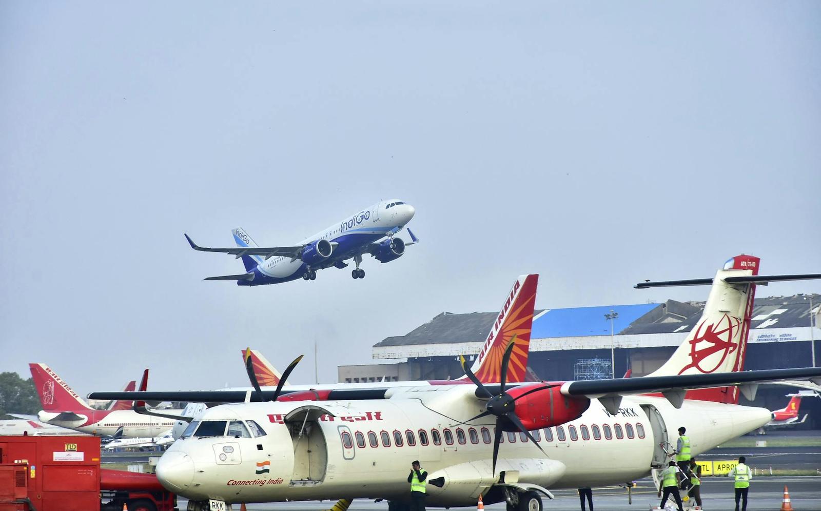 Parked airliners on the tarmac as another plane comes in to land