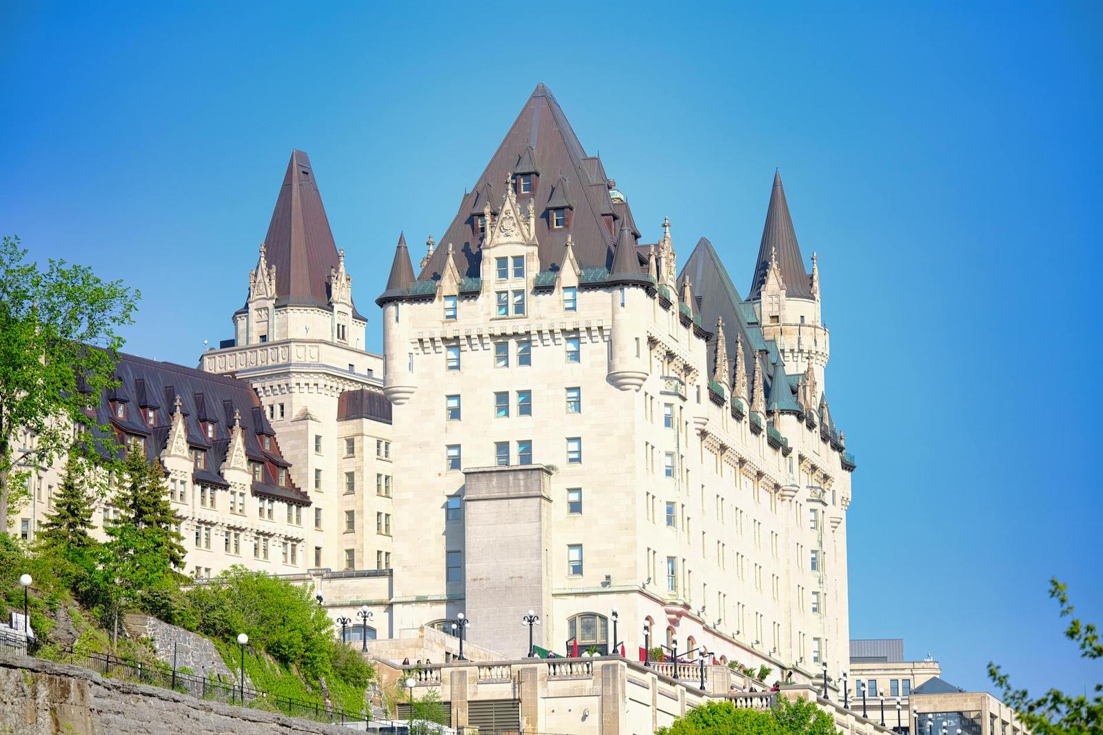 Sunlit view of the iconic Fairmont Château Laurier in Ottawa, Canada, against a clear blue sky