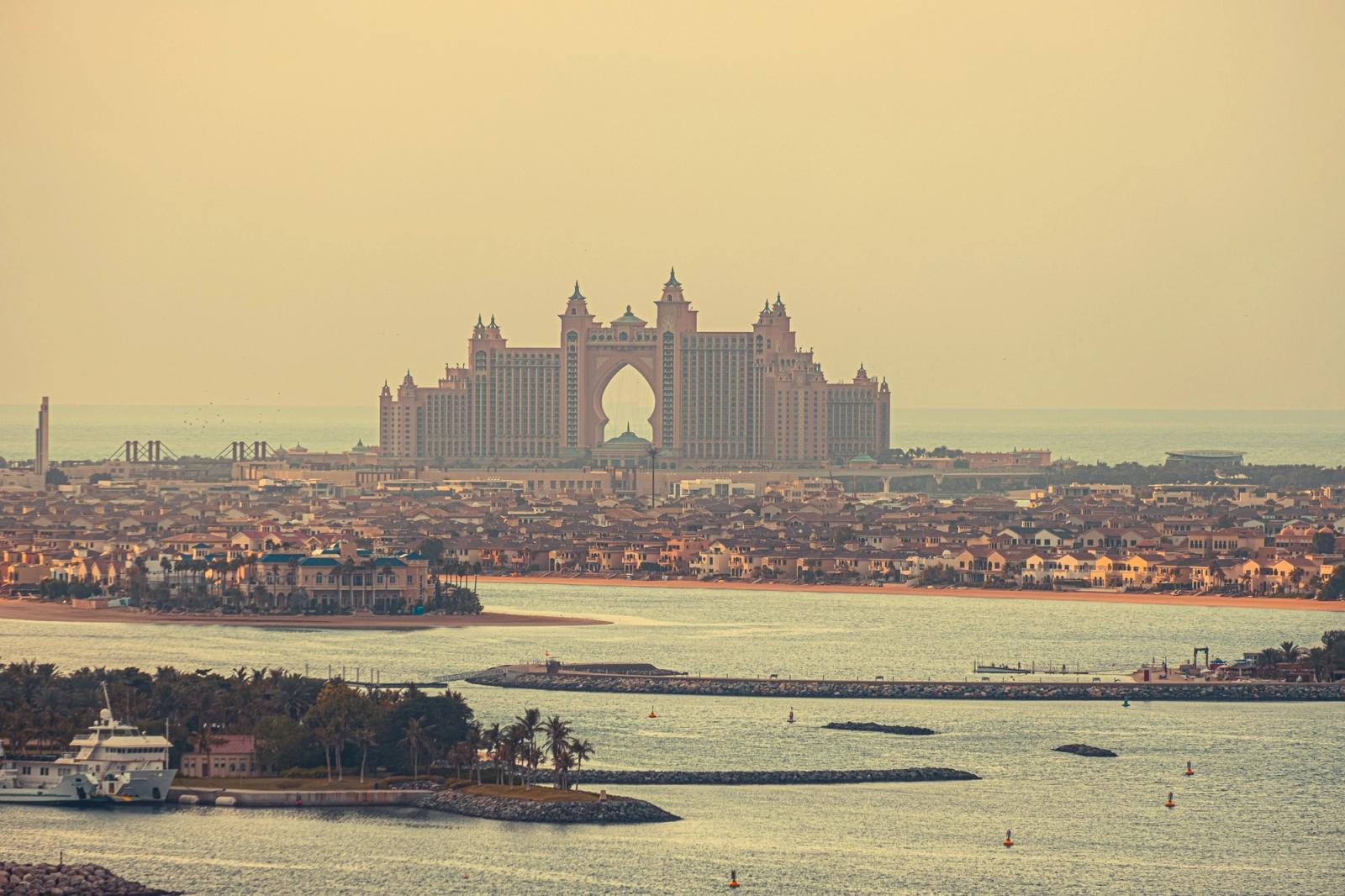 Picturesque view of majestic hotel building in Dubai surrounded by endless ocean and settlement