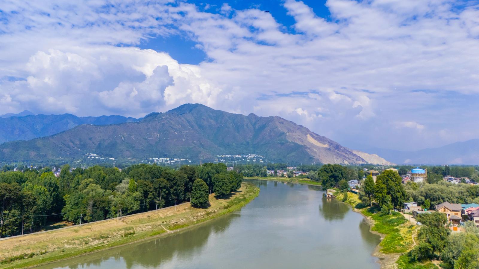 Scenic aerial view of the river and mountains in Srinagar, showcasing lush greenery and blue skies