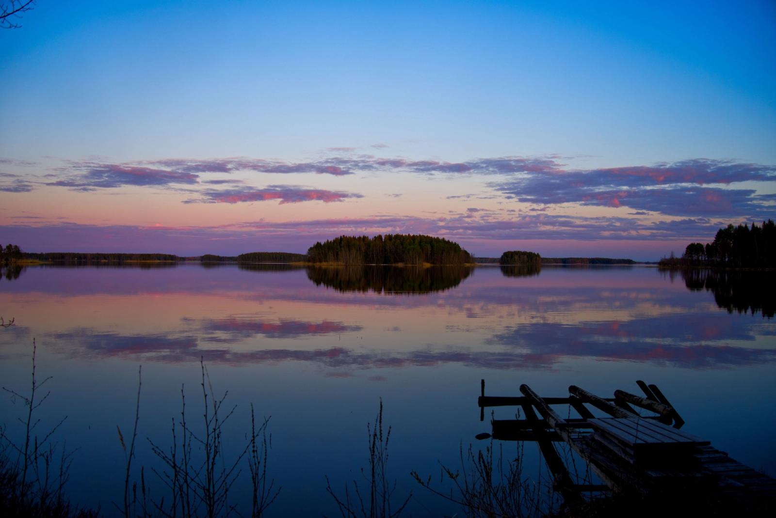 Serene twilight reflections on Evijärvi Lake with a wooden pier in Finland