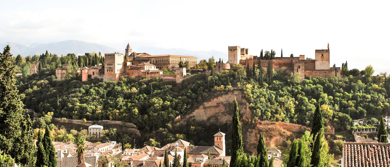 Scenic view of the historic Alhambra Palace in Granada, Spain surrounded by lush greenery