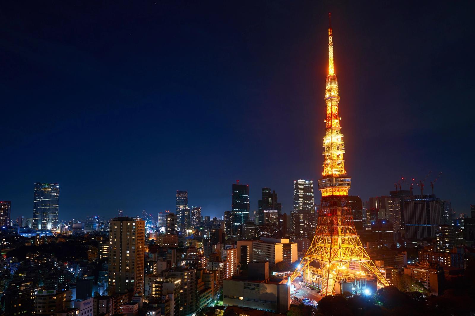 Spectacular view of Tokyo Tower brightly lit against the urban skyline at night