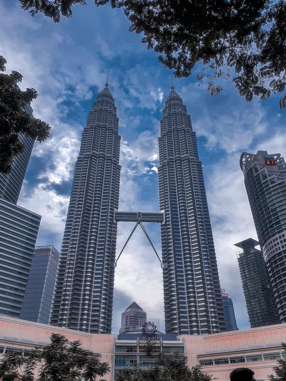 Majestic view of the iconic Petronas Towers in Kuala Lumpur with a moody sky backdrop