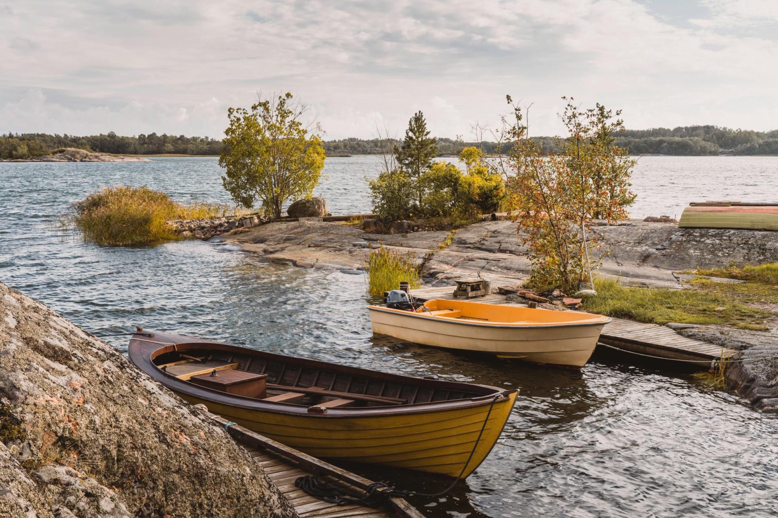 Beautiful wooden boats by the rocky shore in the serene Turku Archipelago