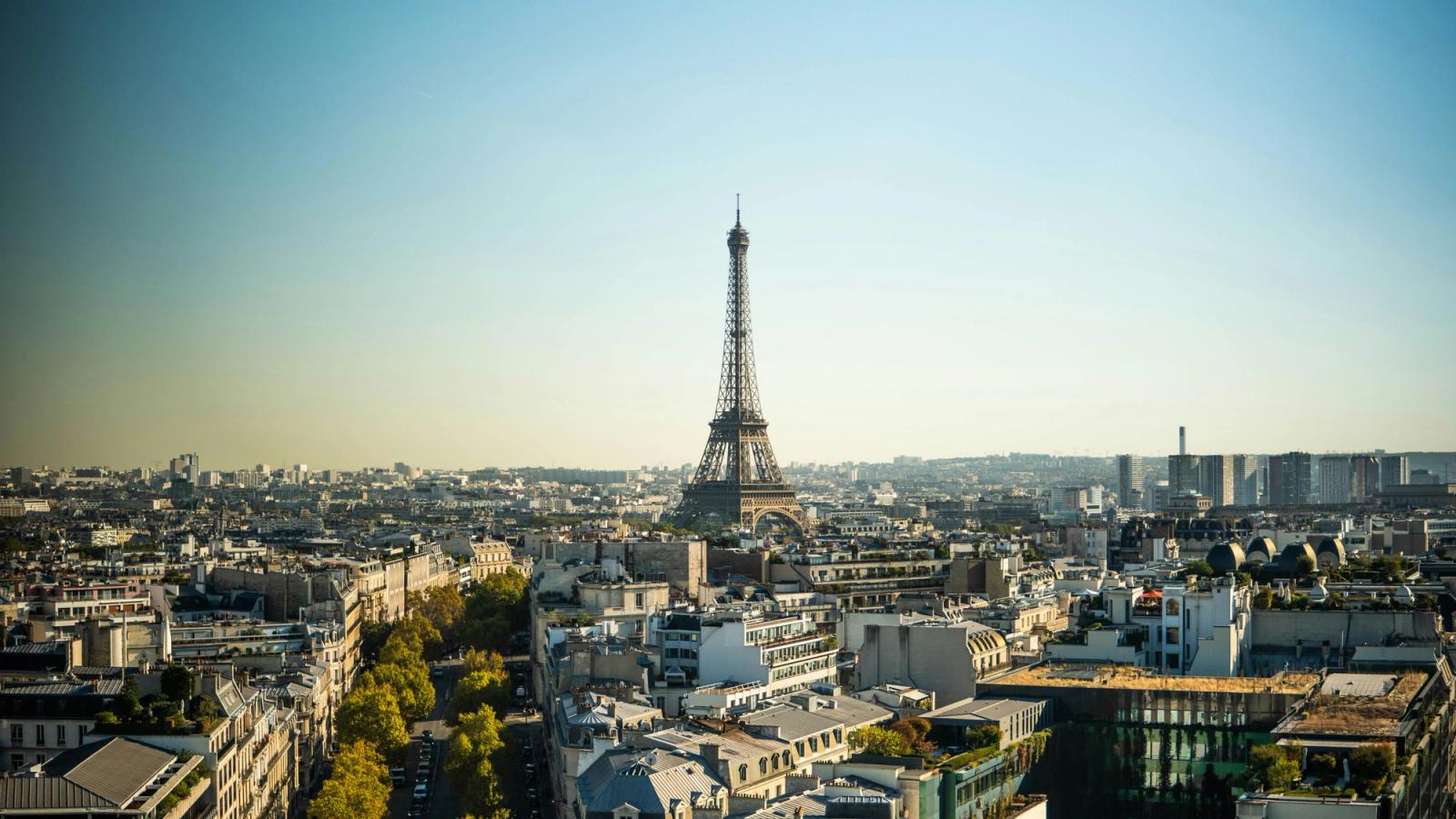 The Eiffel Tower rising above Parisian rooftops on a clear day