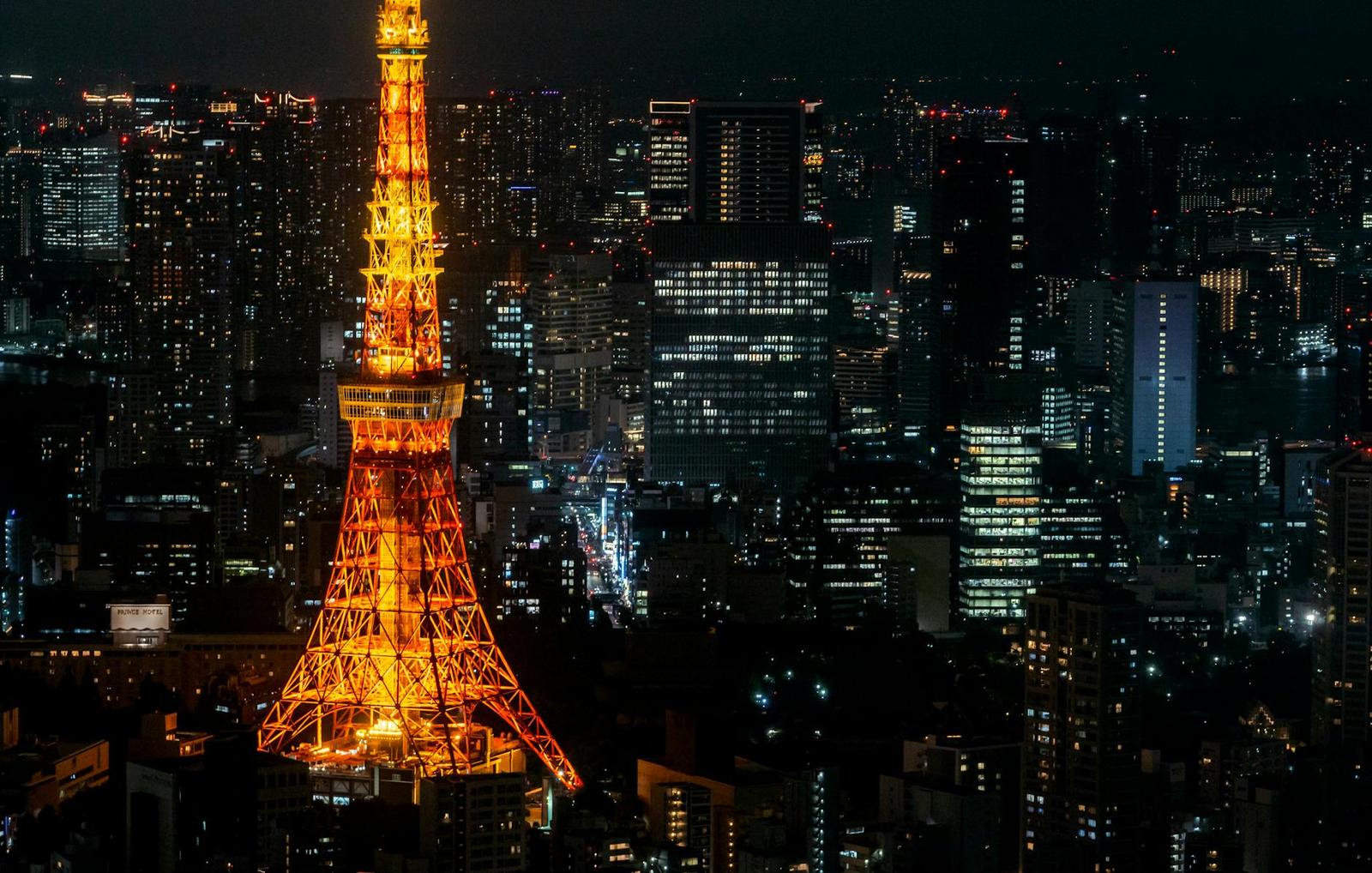 Tokyo Tower glowing orange against a lit-up night skyline