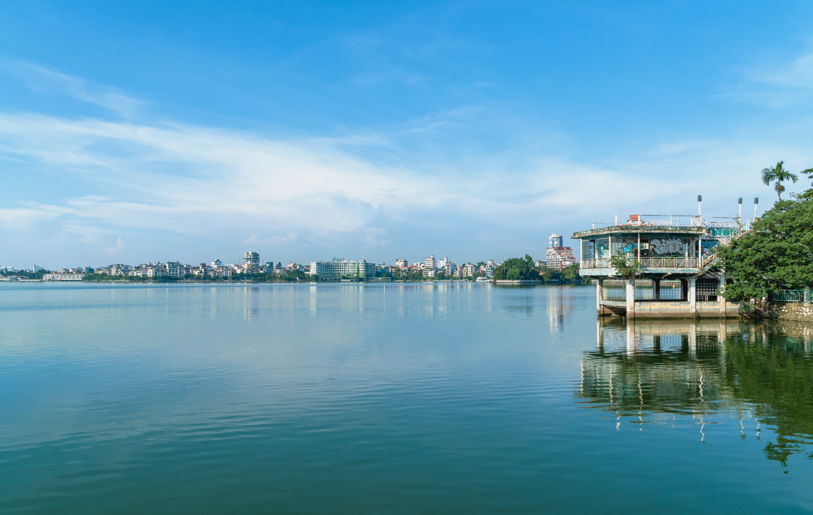 Captivating view of West Lake in Hanoi with cityscape and blue sky reflection