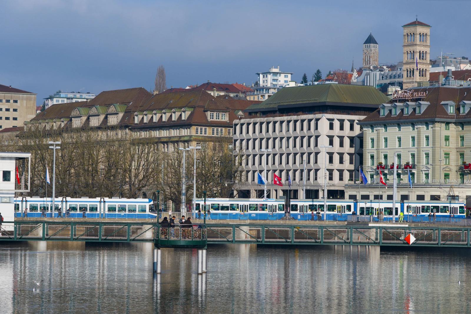 Beautiful view of Zurich's Limmat River with a tram and historic buildings, showcasing Swiss architecture