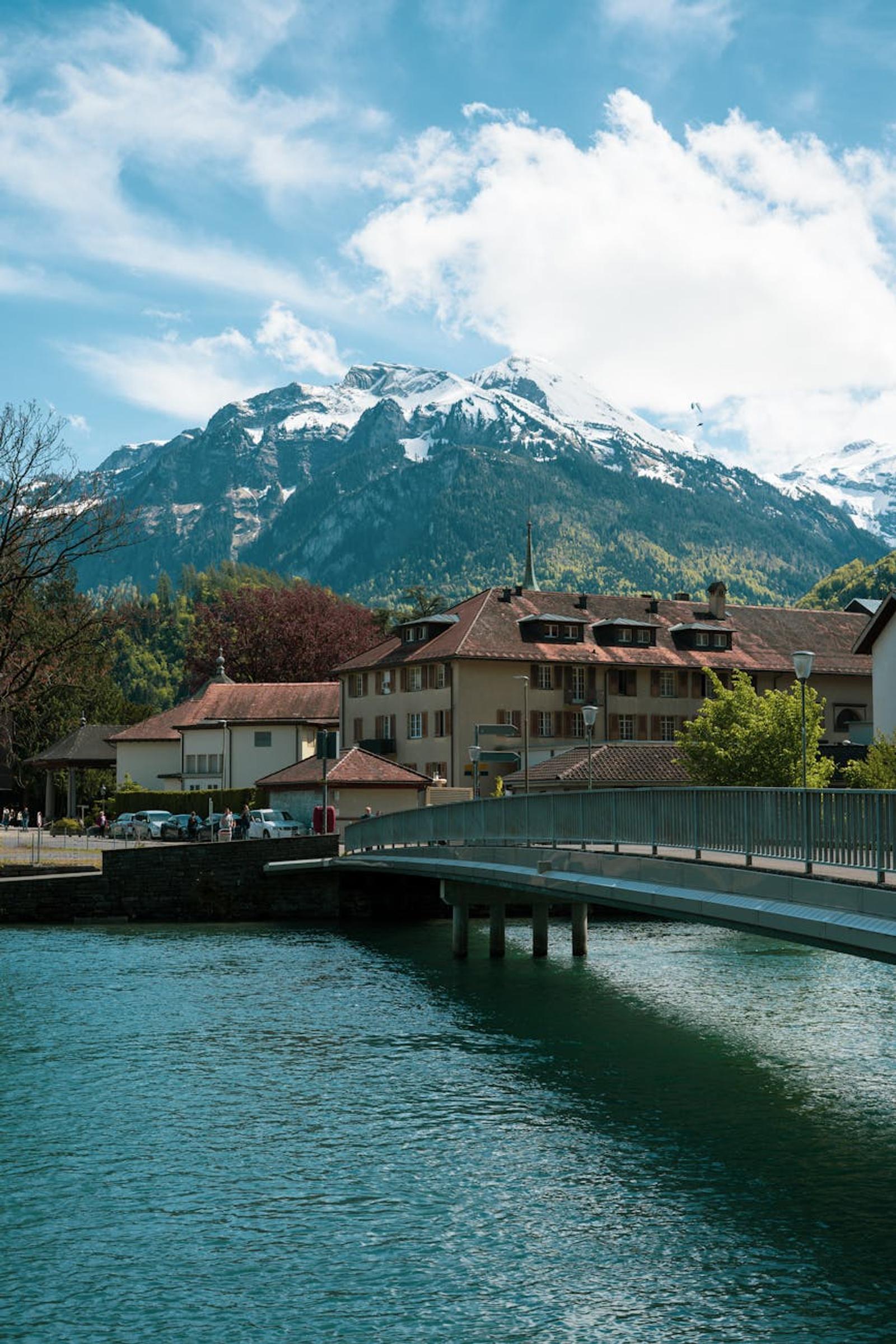 Picturesque view of Interlaken village with a bridge and snowy Alps in the background