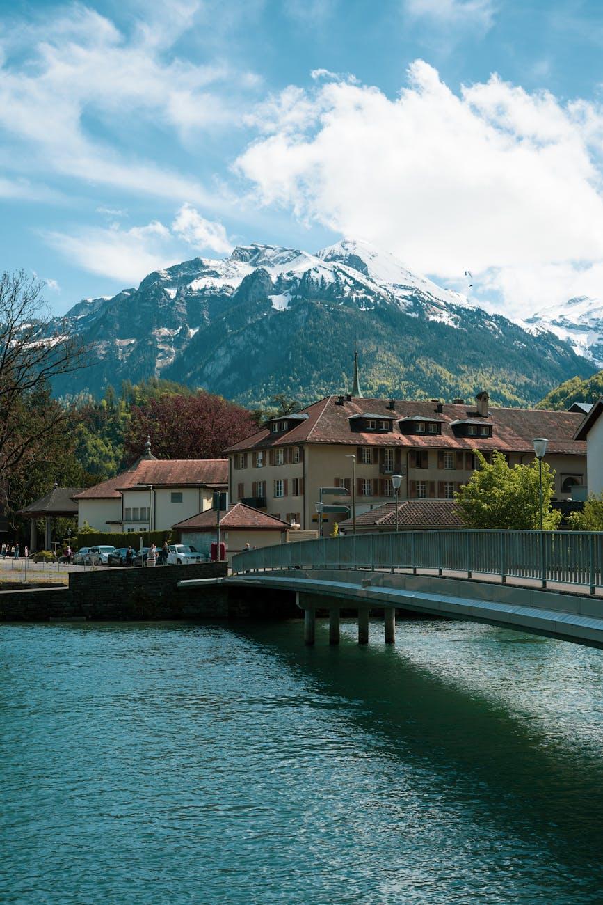 Picturesque view of Interlaken village with a bridge and snowy Alps in the background
