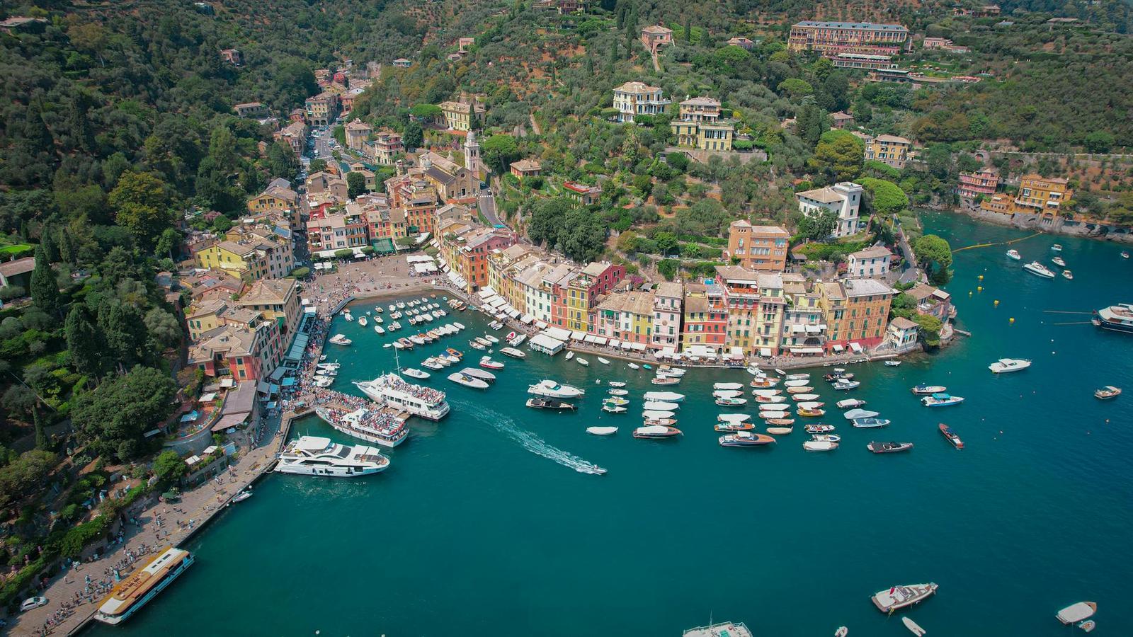 Aerial view of a colourful harbour town with boats moored in a bay