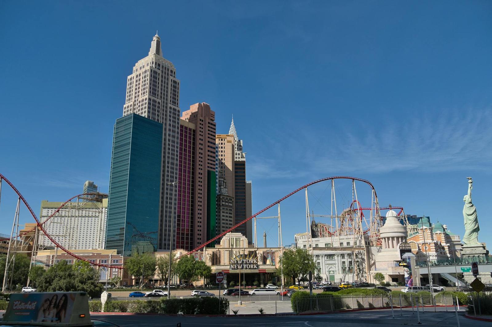 A casino resort skyline styled like a mini Manhattan with a roller coaster and a small Statue of Liberty replica