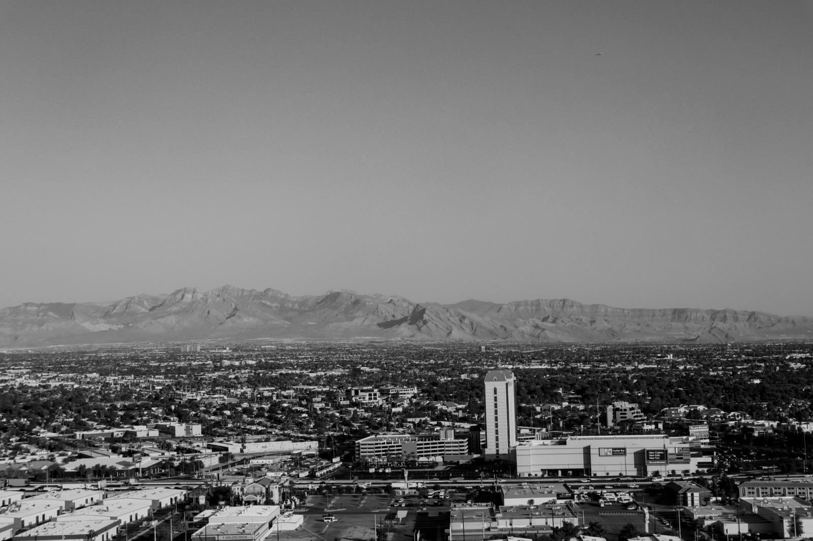 Black and white aerial shot of Las Vegas cityscape with mountains