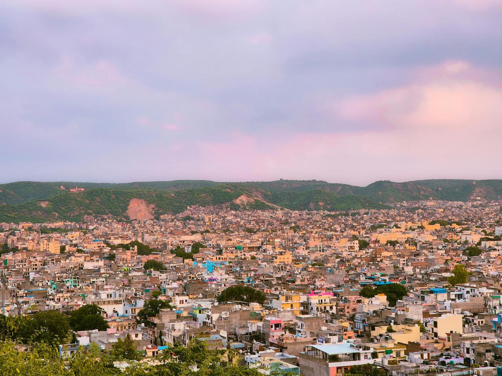 A hillside city bathed in soft pink evening light