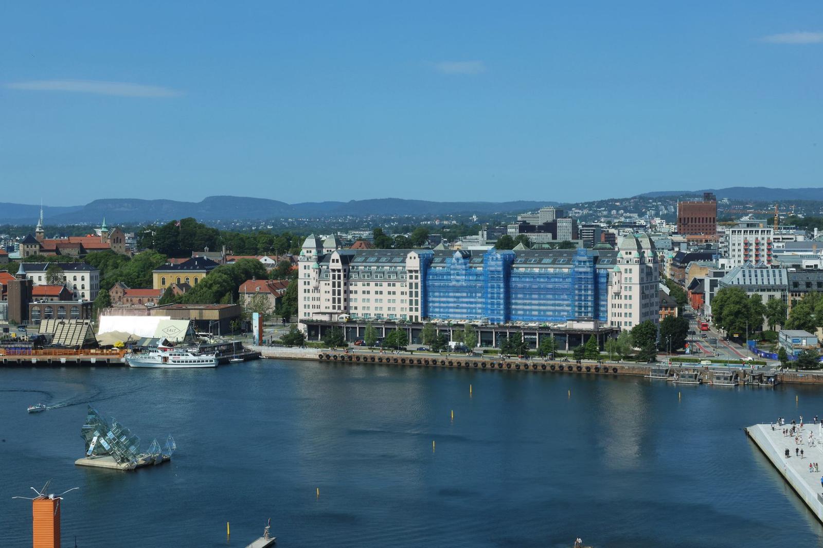 Blue-glass waterfront apartment towers overlooking a marina under a clear sky