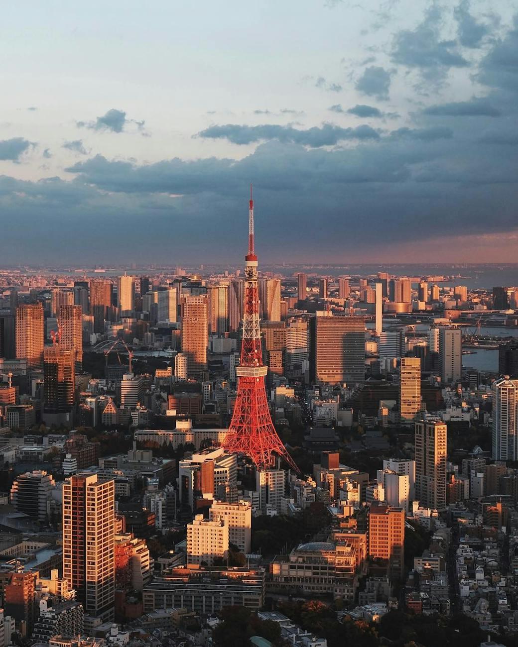 Aerial view of Tokyo Tower glowing red among skyscrapers at dusk