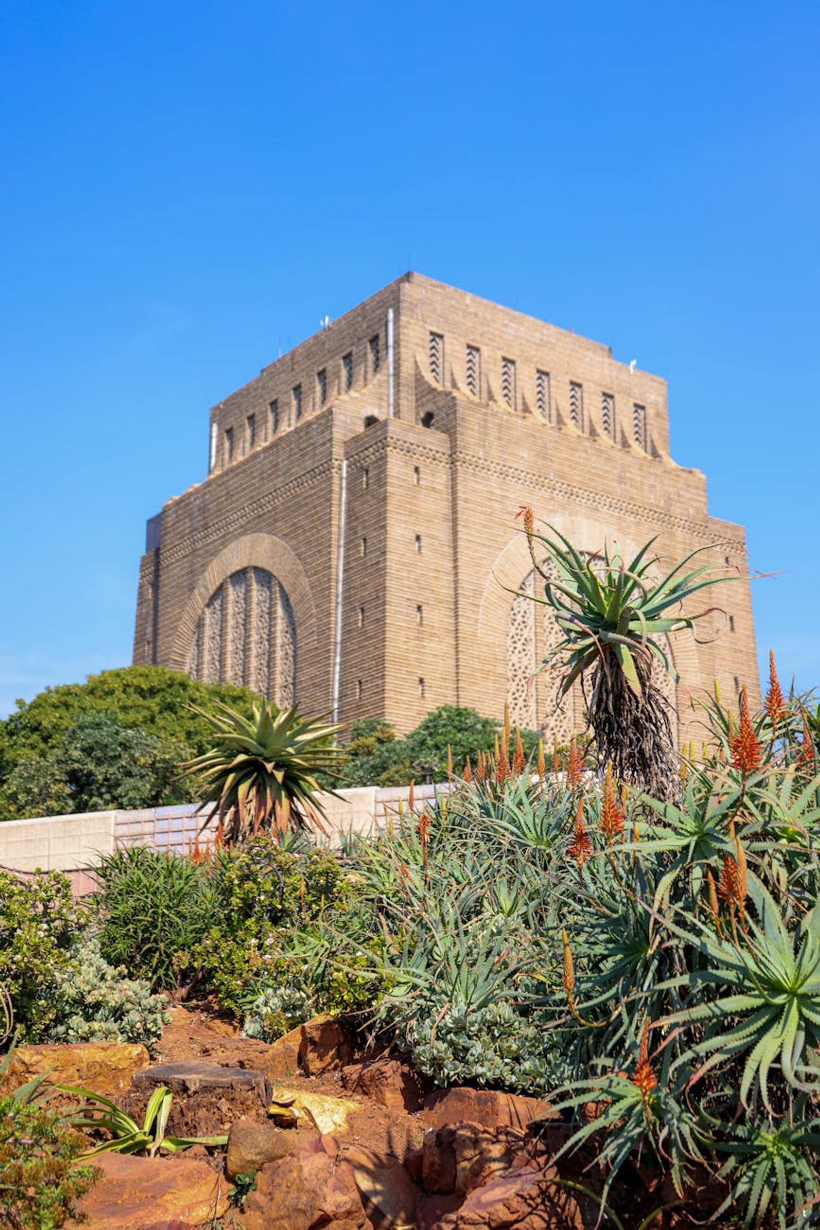 Voortrekker Monument surrounded by lush gardens under a clear blue sky in Pretoria