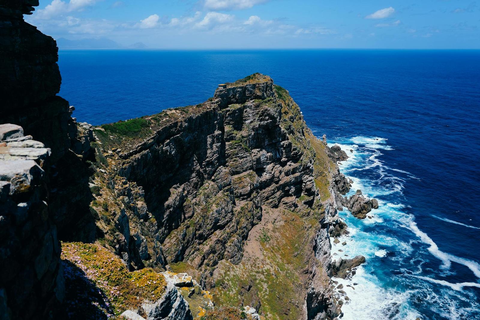 Dramatic rocky headland jutting into deep blue ocean