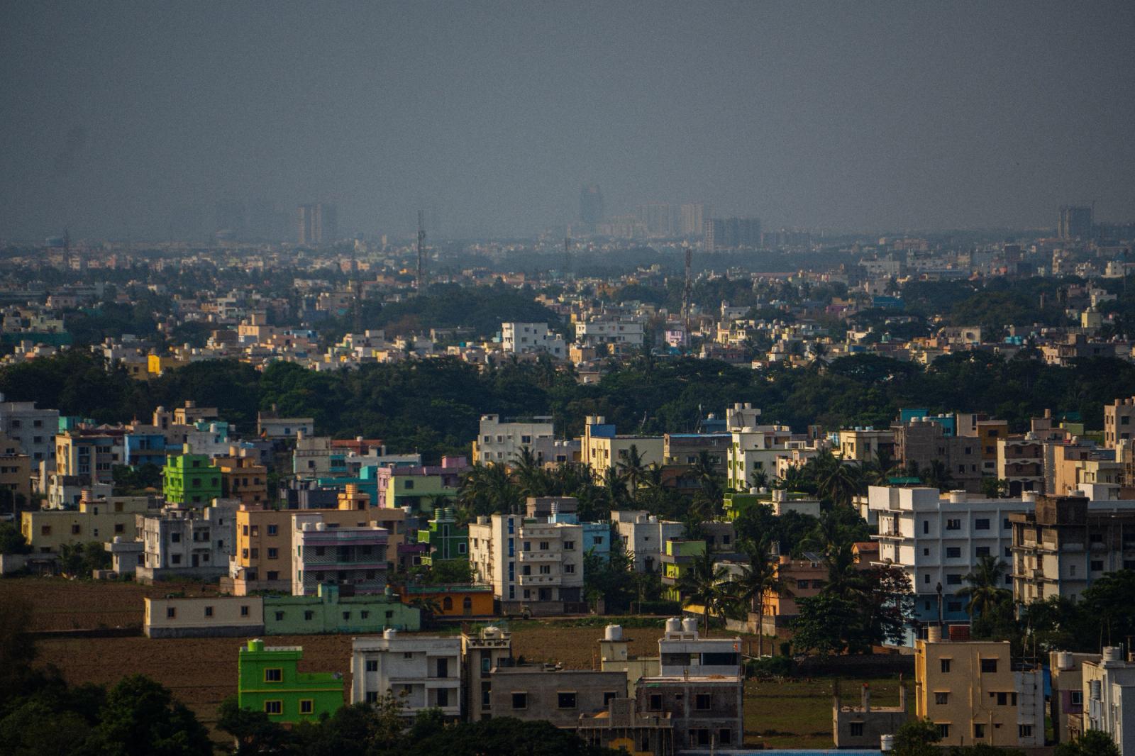 Aerial view of urban buildings and lush greenery in Bhubaneswar, India, showcasing vibrant architecture and dense population
