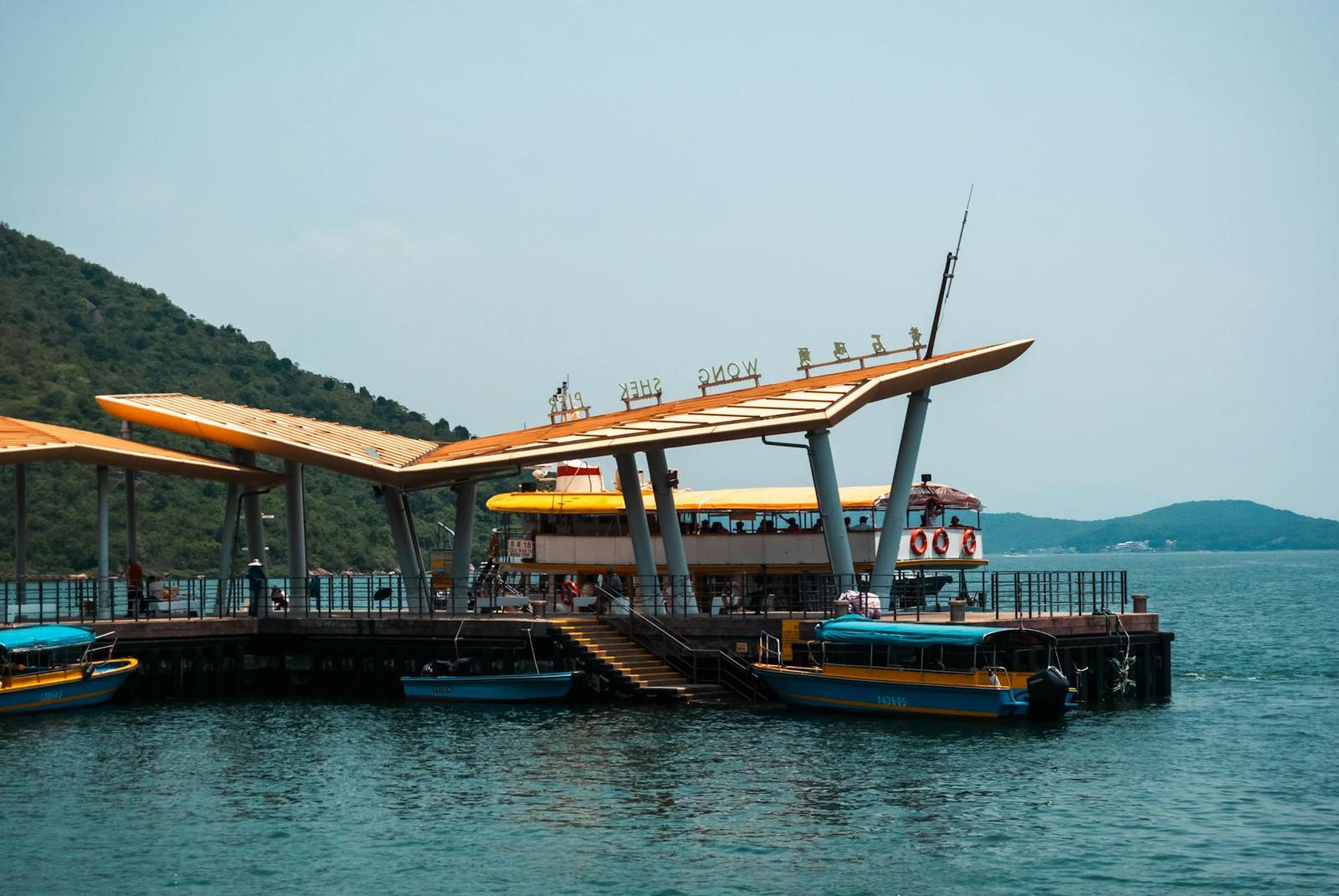 Waterfront pier with an orange canopy roof and boats docked alongside