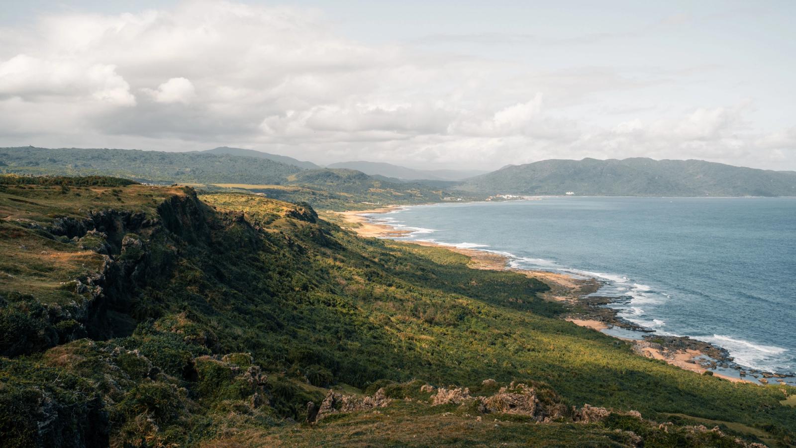 A breathtaking aerial view of lush greenery and ocean along Taiwan's coastline