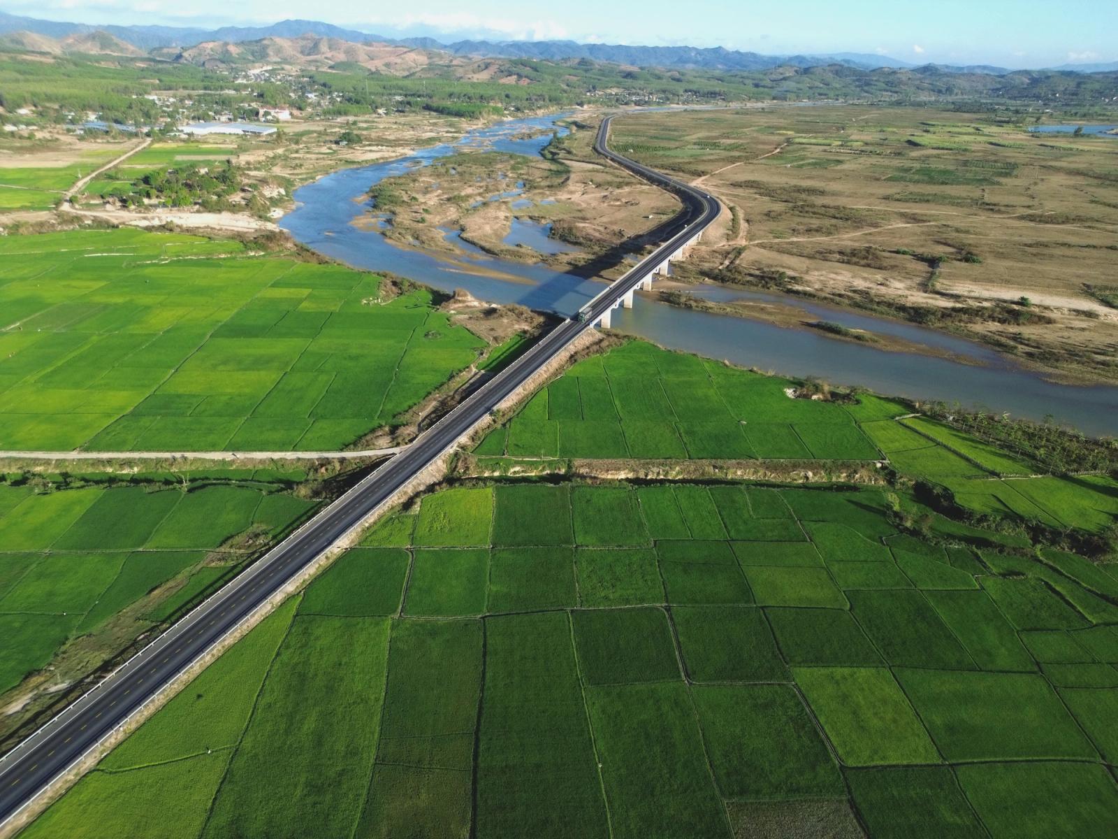 Aerial view of green rice fields, river, and bridge in Kon Tum, Vietnam