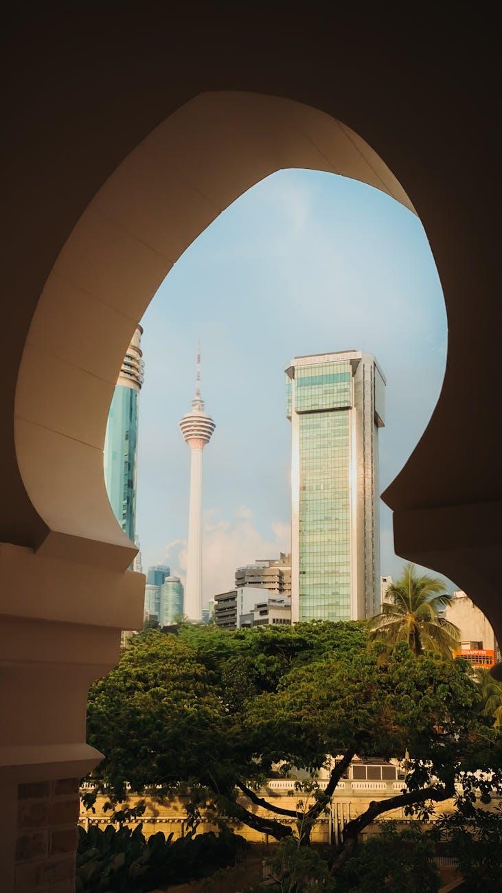 City skyline framed through a keyhole-shaped stone archway with a tall tower visible