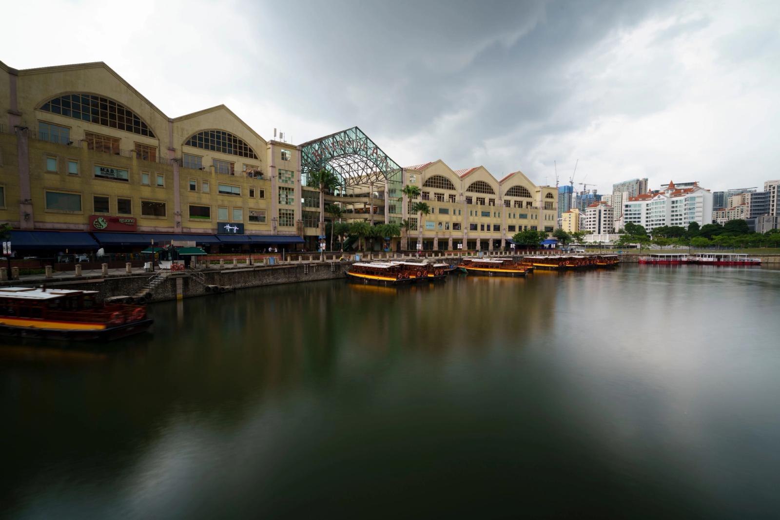 Dramatic view of a riverside urban area with distinctive architecture and boats along the waterfront