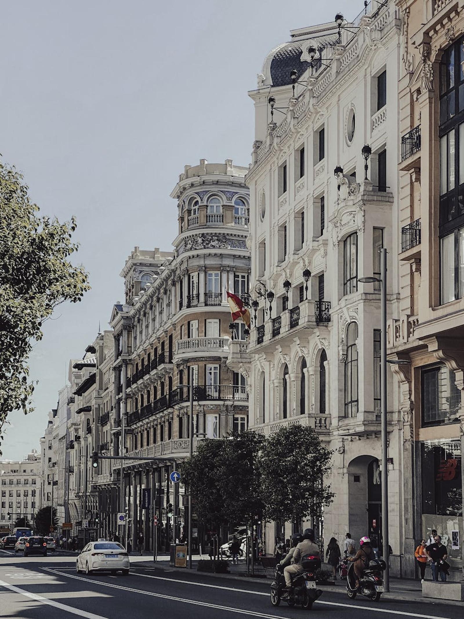 Ornate European avenue lined with historic buildings and street scooters