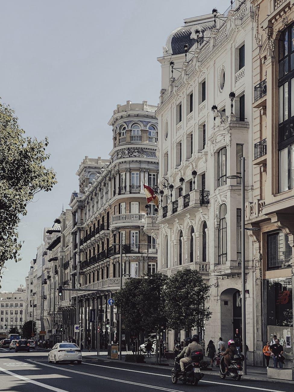 Ornate European avenue lined with historic buildings and street scooters
