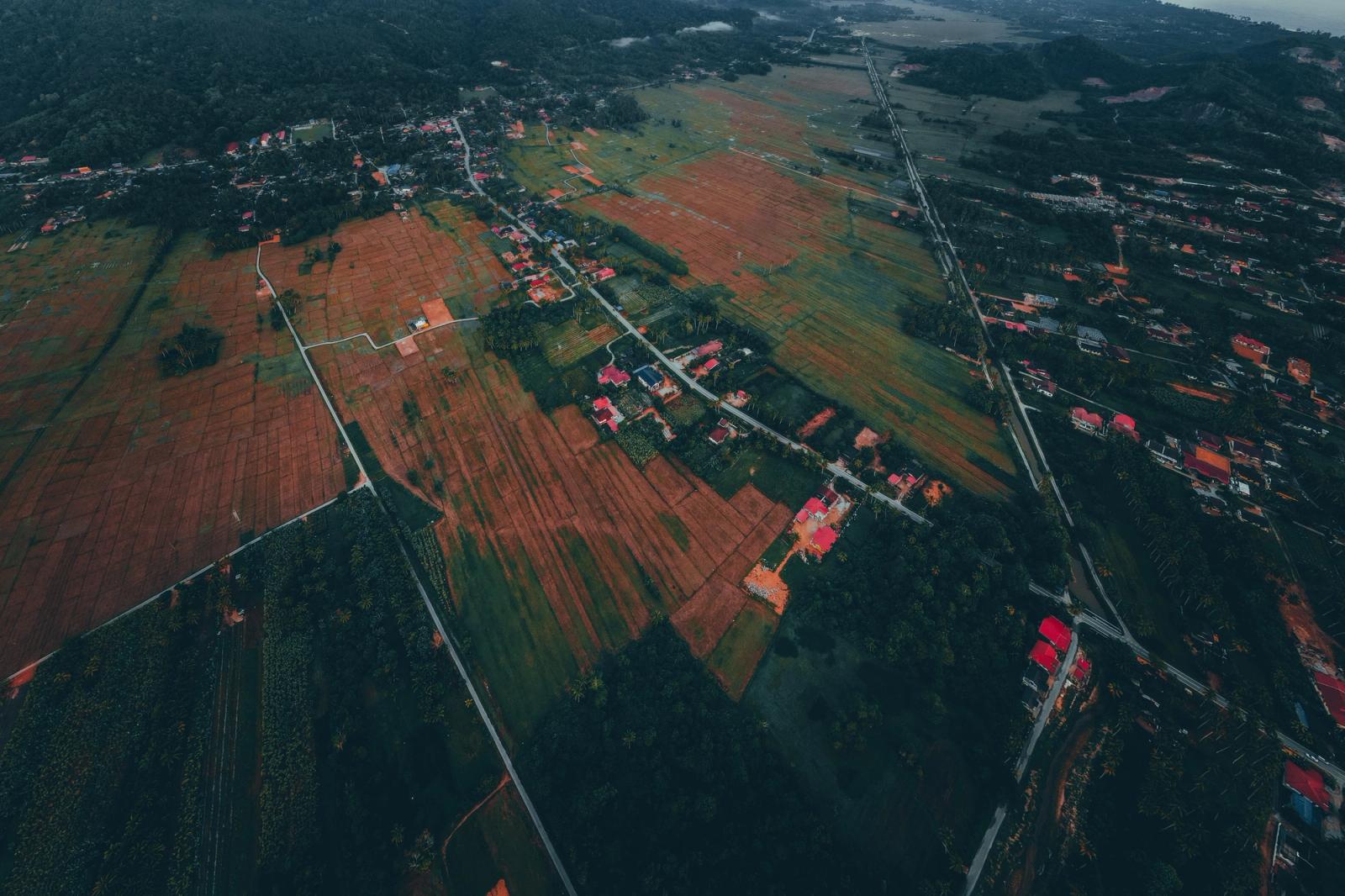 Scenic aerial view of rural farmland in Kuala Terengganu, Malaysia, showcasing fields and countryside houses
