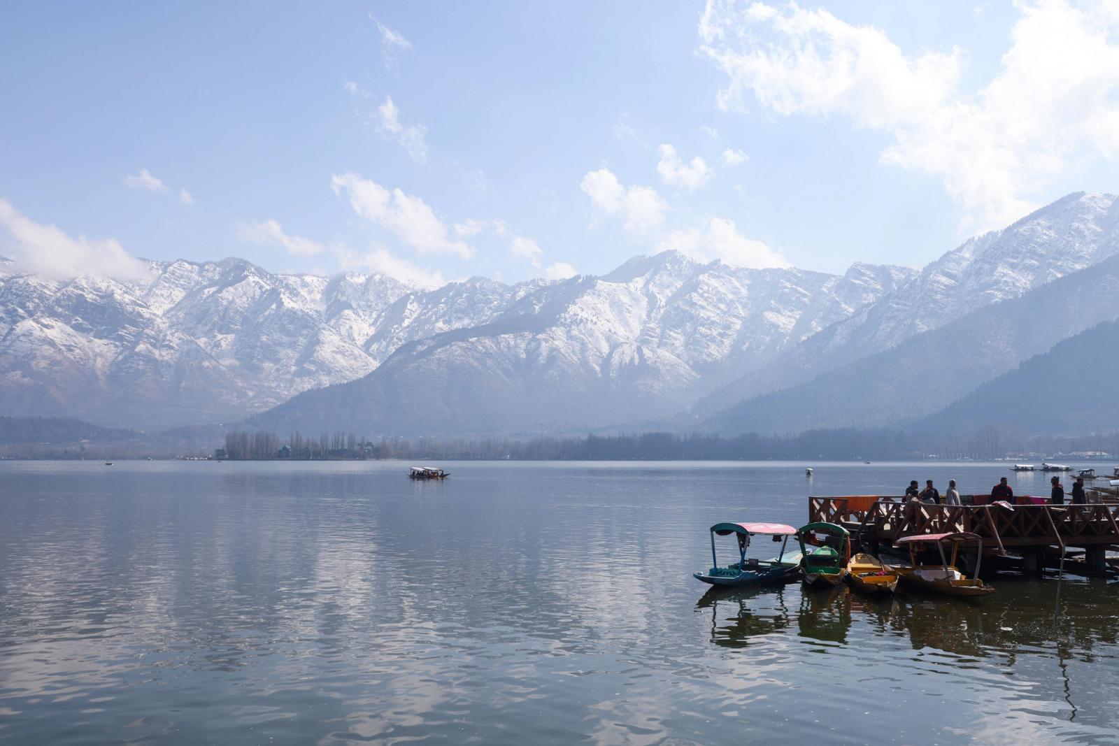 Boats on Dal Lake with snowcapped Himalayas in the background, serene Srinagar scene